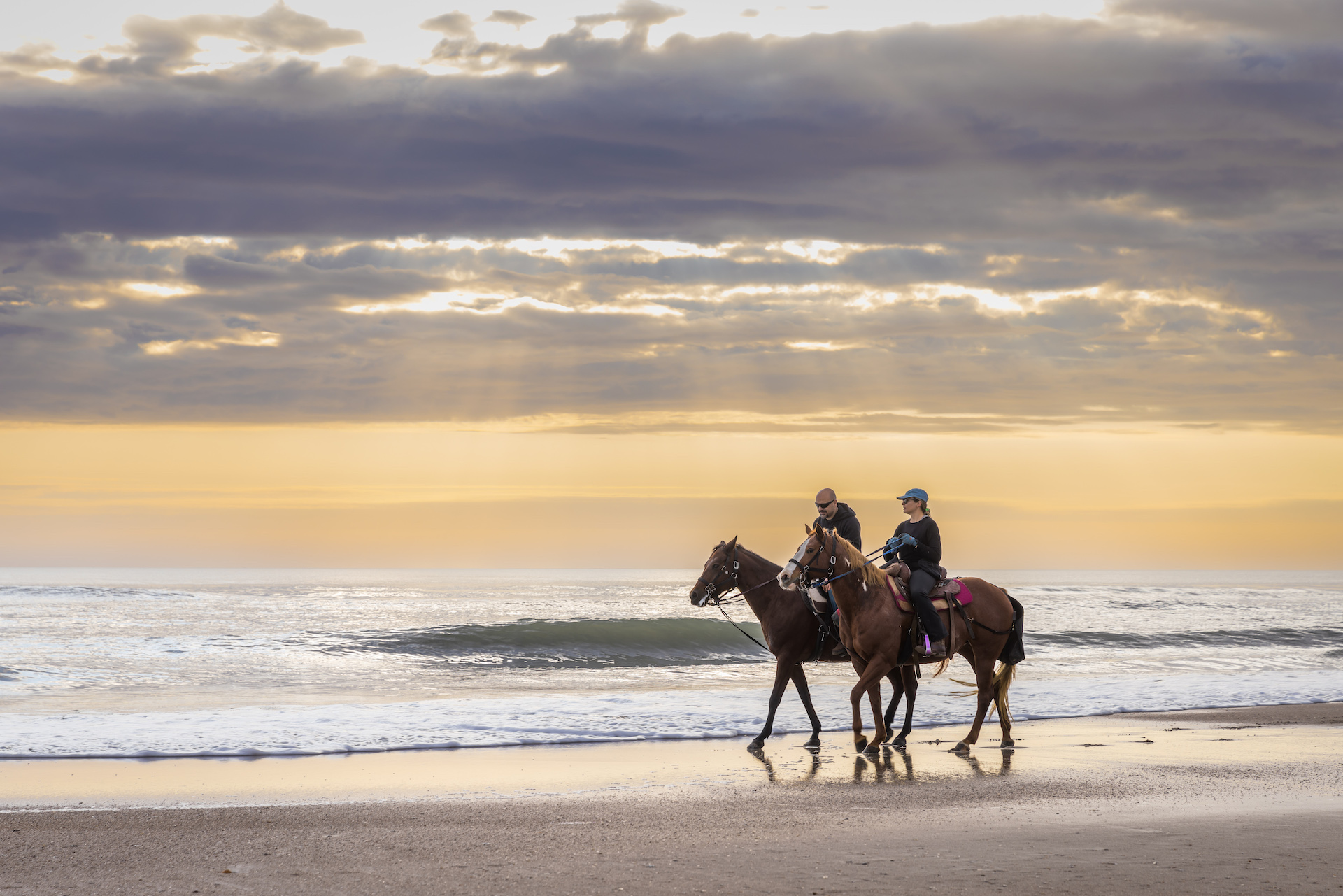 Couple riding horses on Amelia Island beach